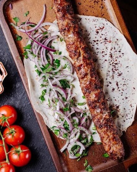 Grillad kebab på tunnbröd med rödlök, persilja och tomater
